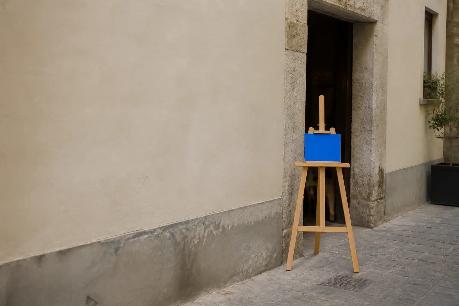 Cavalletto vuoto all'ingresso del ristorante con piccolo cartellino blu cobalto completamente illeggibile.
